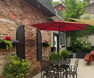 Outdoor patio with plants and flowers, cozy seating, umbrellas, and picnic tables